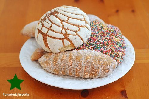 A plate of pan dulce: a concha, a sprinkle-topped roll and a sugared cuerno